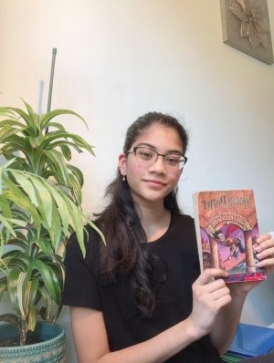 Book club member junior Rashmi Kanipakala displays her favorite book, Harry Potter and the Sorcerers Stone by J.K. Rowling.