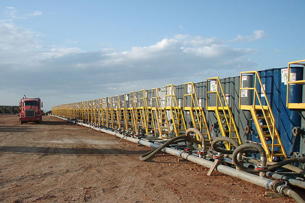 The image captured depicts the water consumption of fracking. Hundreds of water tanks are lined up, ready to use.