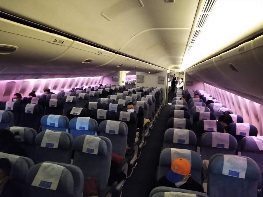 A nearly empty flight, practicing social distancing and mask wearing to prevent the spread of COVID-19.
