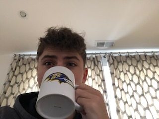 Freshman Joshua Mirsky drinks hot chocolate on a winter day while watching the Baltimore Ravens play.