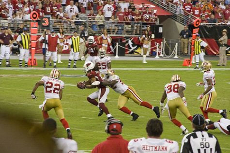 Wide receiver Larry Fitzgerald gets tackled by division rival Patrick Willis as time expires.