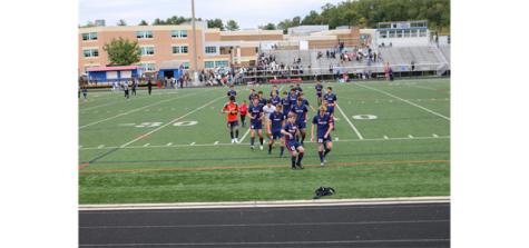 Boys varsity soccer celebrates after winning the Division Championship in 2019 on the schools turf field.