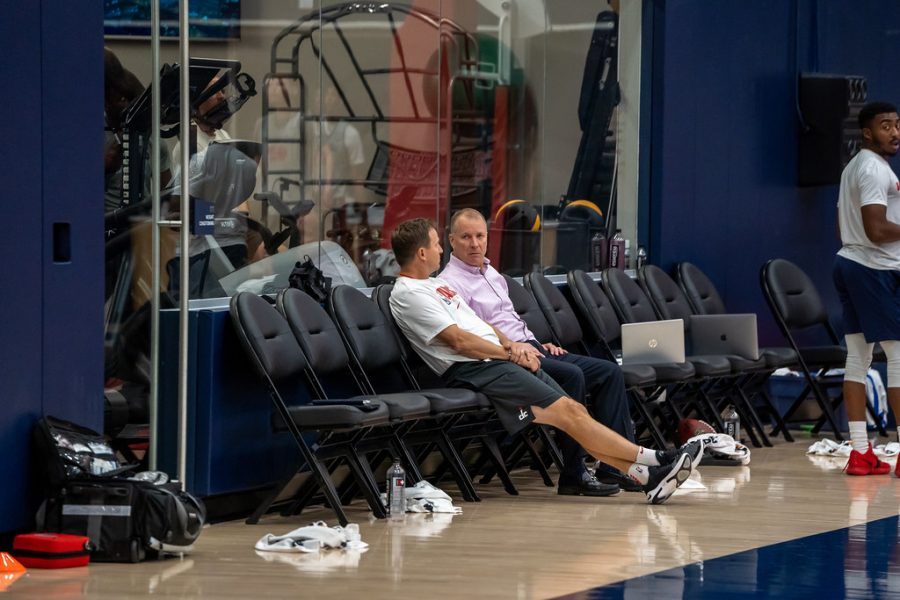 Scott Brooks sits with general manager Tommy Sheppard during a Wizards practice