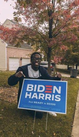 Junior Ted Otengo with a Biden Harris yard sign days before the presidential election in November.