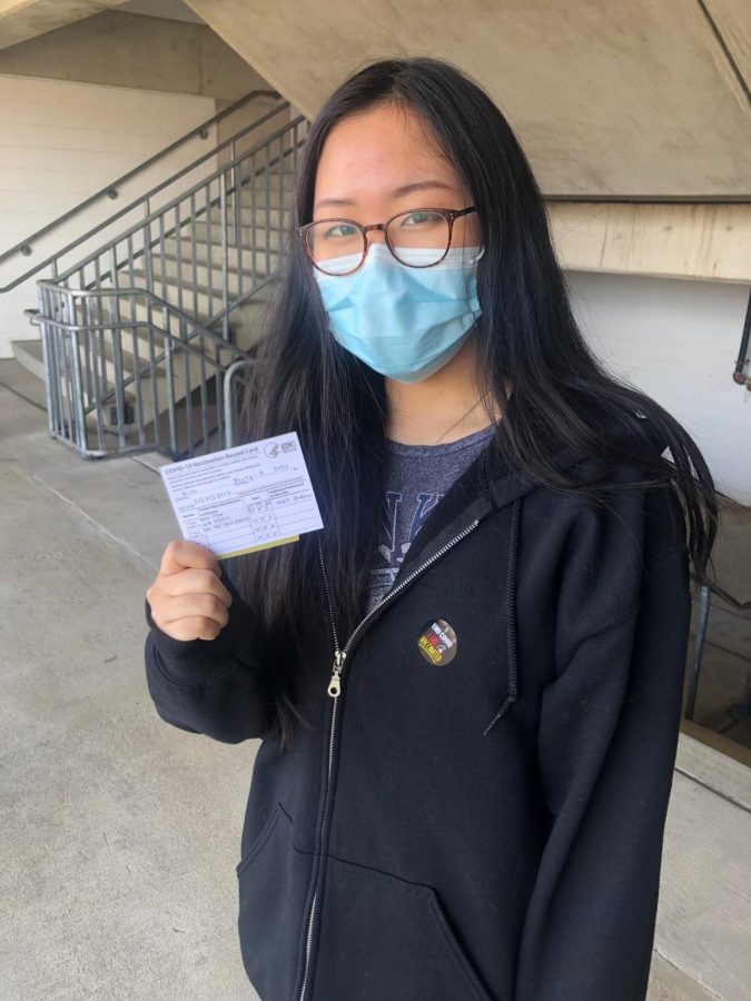 Young-A Kim holds her vaccination card at the exit of the M & T Stadium on Mar. 19.