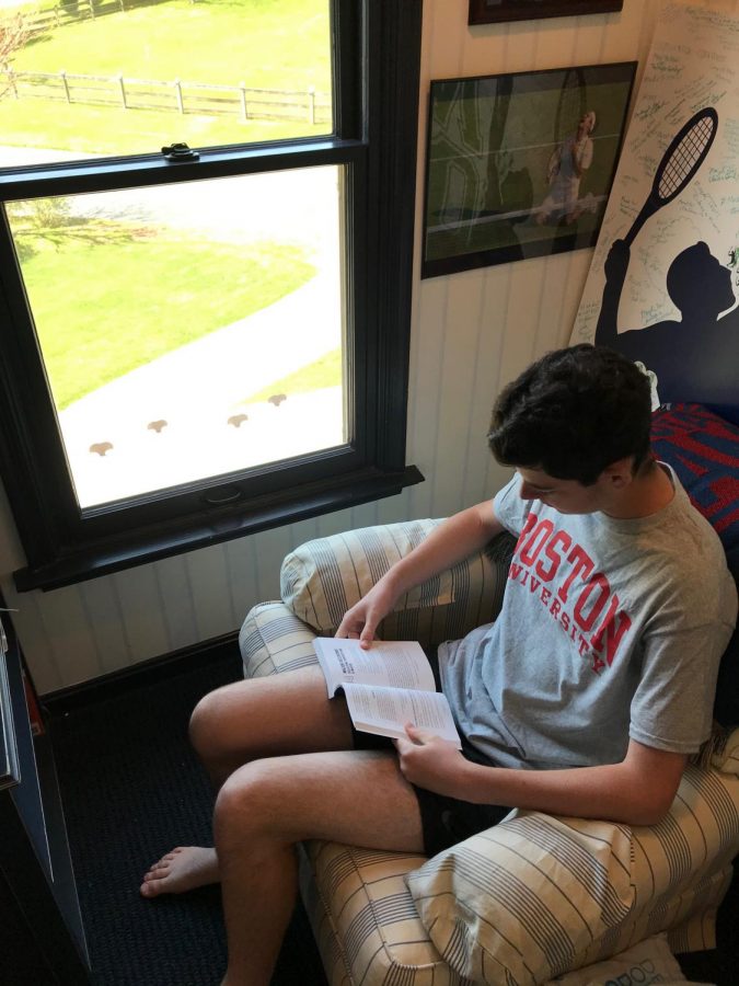 Noah Lenkin reads a book that will help prepare him for college at Boston University