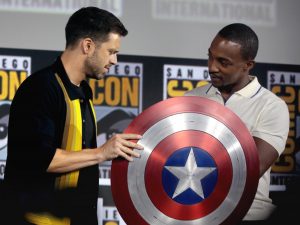 Anthony Mackie and Sebastian Stan observe Captain Americas shield.