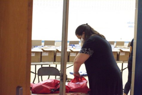 Social studies teacher Christy Rice packs and helps distribute bags with graduation caps, gowns, stoles, ribbons, and more to seniors on May 22 during Unity Day.