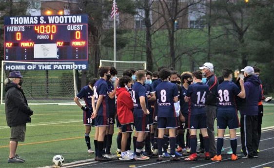 Boys varsity soccer huddles before a game.