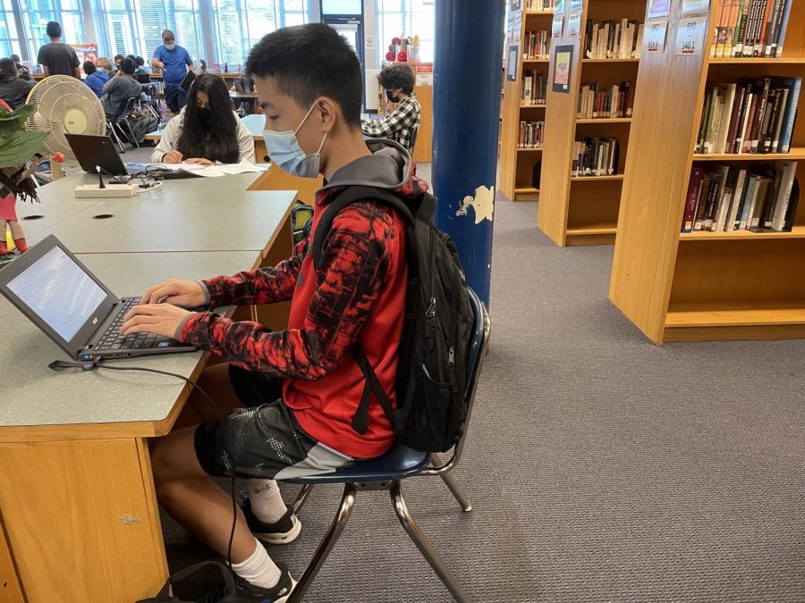 Sophomore+Nick+Peng+does+his+English+homework+in+the+library+as+he+deals+with+adjusting+to+in-person+learning.
