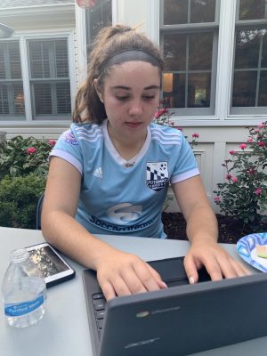 Freshman Kailey Waxman does her homework after soccer practice while at a friends house.