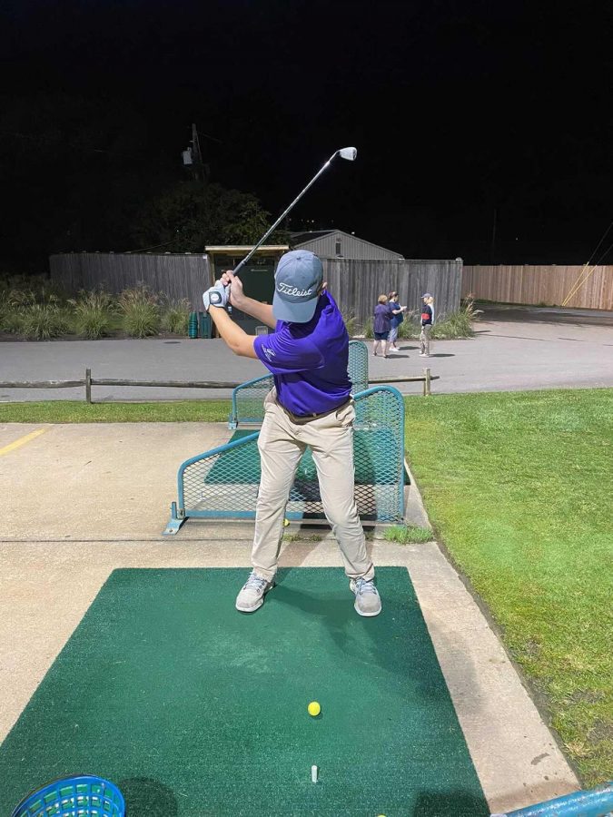 Senior Devon Graham takes a swing during his shift at Falls Road Golf Course, where he works, on Oct. 12.