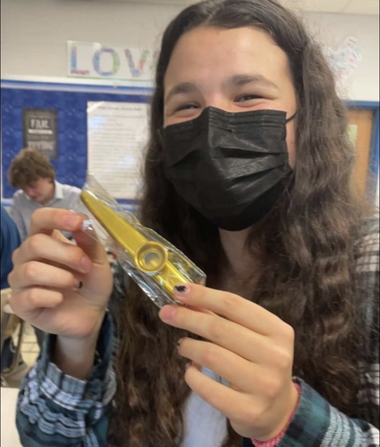 Junior Bella Bargman, member of the Kazoo Keepers, holds a golden kazoo in preparation for their next performance.