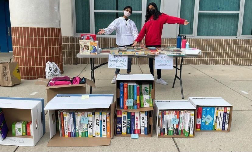 Senior Neha Dheen and sophomore Divya Subramaniam celebrate a successful book drive outside school on Oct. 29.