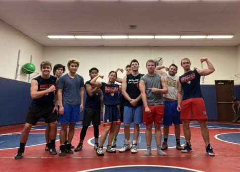 The varsity wrestling squad and head coach Shane Bramble celebrate after a demanding winter break practice on Dec. 30.