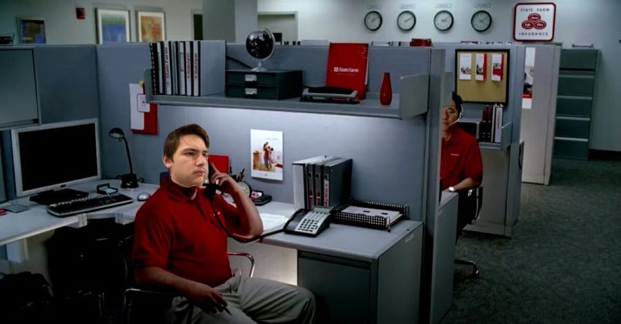 Senior Luke Jordan sits at his desk in the State Farm headquarters, describing his pants to an enraged lady over the phone.