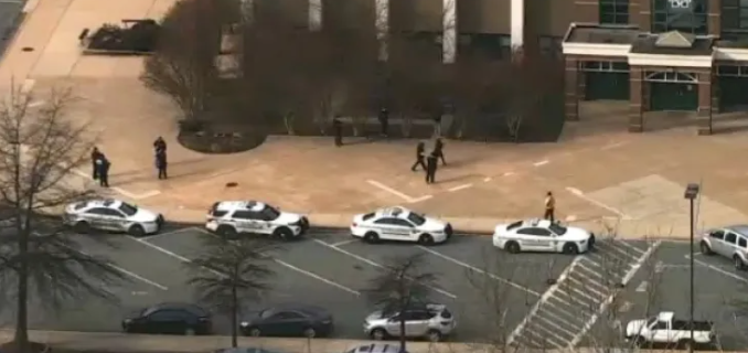 Police cars arrive at Magruder after the shooting.