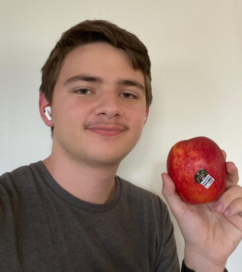 Senior Luke Jordan holds up a Juici apple moments before biting into it.