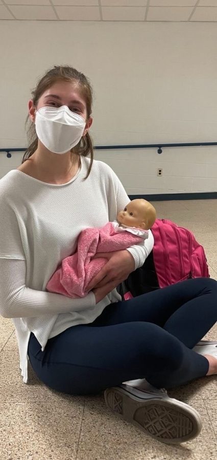 Senior Hannah Eisenfeld cradles the baby doll that she was assigned to watch over throughout the school day.
