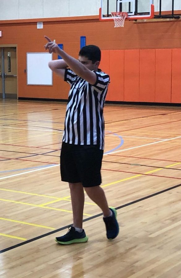 Ethan Berman prepares to officiate a youth basketball game.