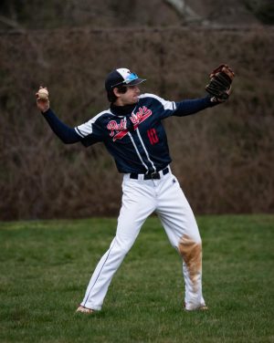 Senior Rob Carpenter throws the ball in the outfield on Saturday, Mar. 26, in the 24-0 win against Watkins Mill.