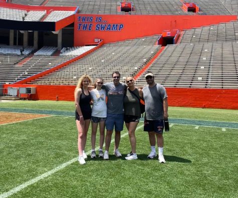 Junior Gillian Berman stands in the center of the University of Florida field with her family during her spring break college tour.