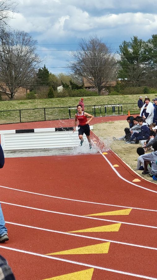 Junior+Rebecca+Vasconez+completes+the+water+obstacle+during+the+steeplechase+at+Urbana.