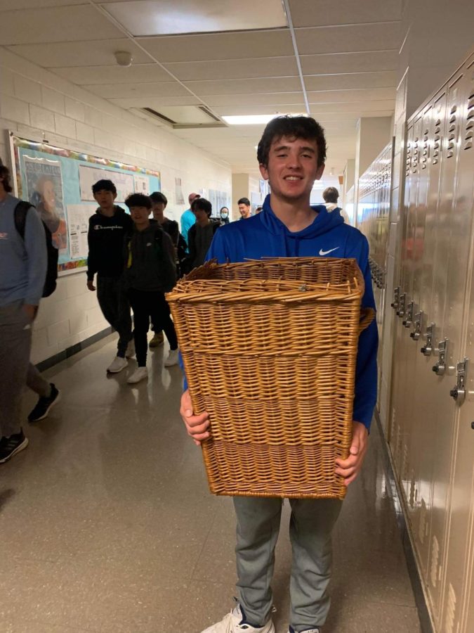 Senior Miles Wiley totes his materials to school in a laundry basket brought from home for Anything but a Backpack day Apr. 20.