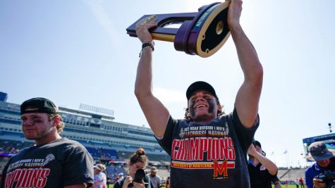 Face off specialist Luke Wierman lifts the NCAA Lacrosse Championship trophy high over his head.