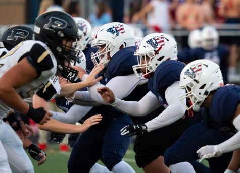 The Patriots varsity football team collides with Poolesville during the first home game of the season.