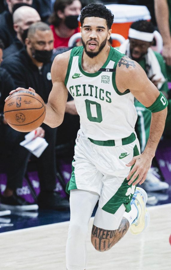 Three-time NBA All-Star Jayson Tatum dribbles the ball downcourt for the Boston Celtics.