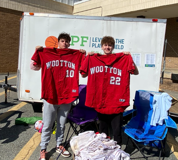 Senior Ryan Kunst and sophomore Matthew Kunst showcase the old baseball school baseball jerseys that were donated.