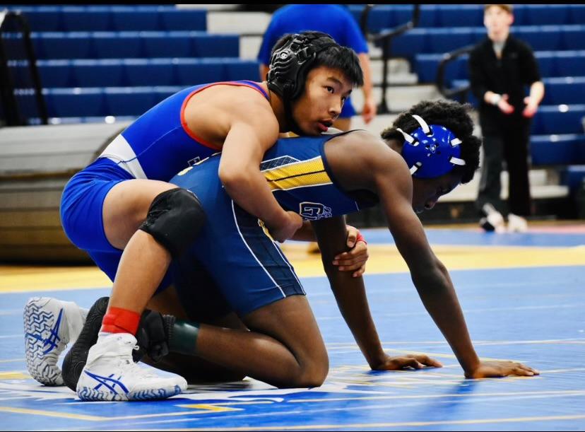 Sophomore Argil Bilegsaikhan shows off a wrestling move he learned in practice during his match.