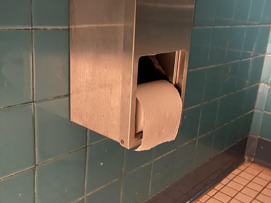 In a school bathroom, a roll of toilet paper hangs facing out, which is how it should be.