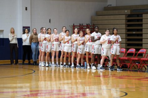 The girls varsity basketball game stands for the Pledge of Allegiance before a game.