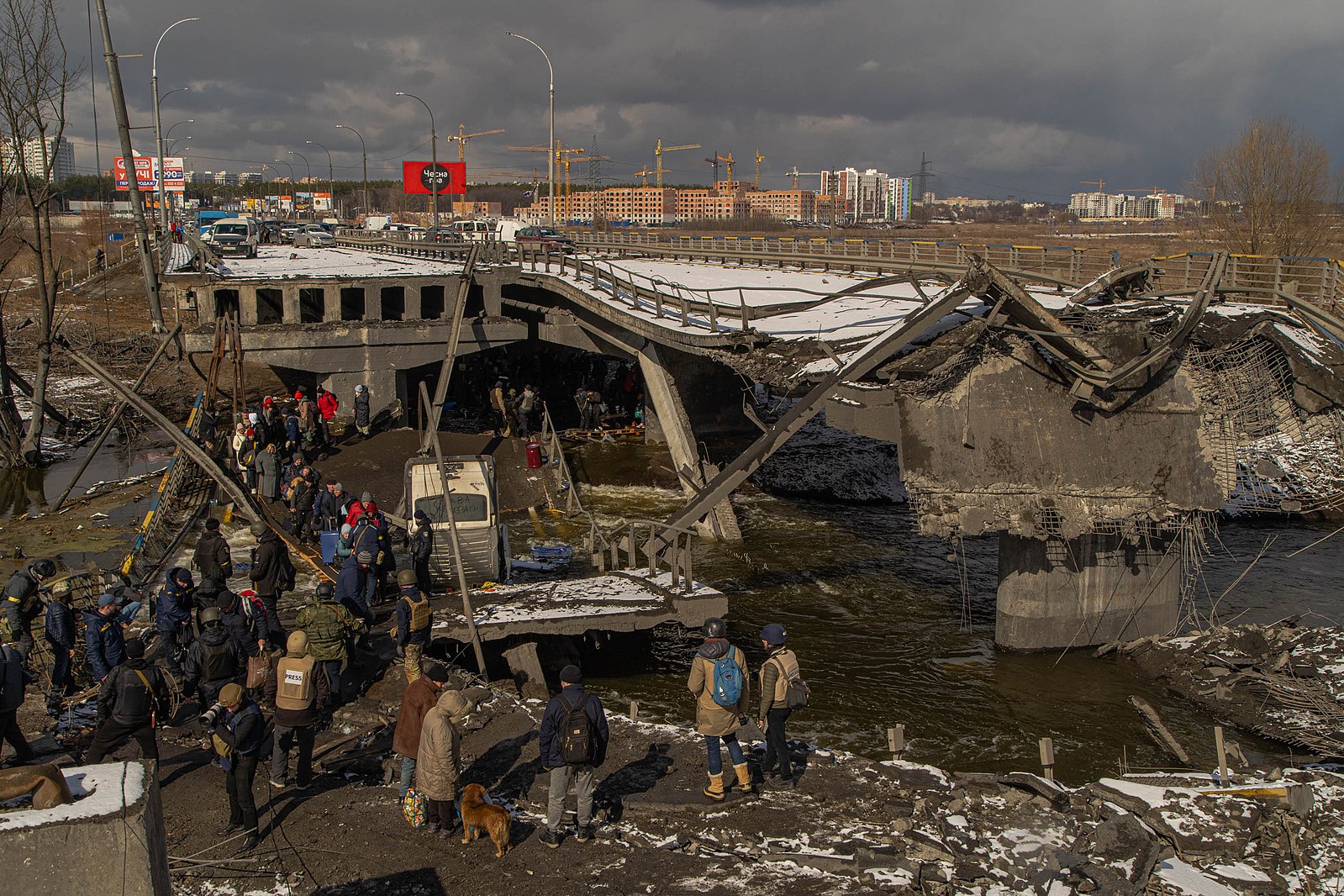 Civilians walk along improvised path next to the bombed Irpin bridge in Ukraine.