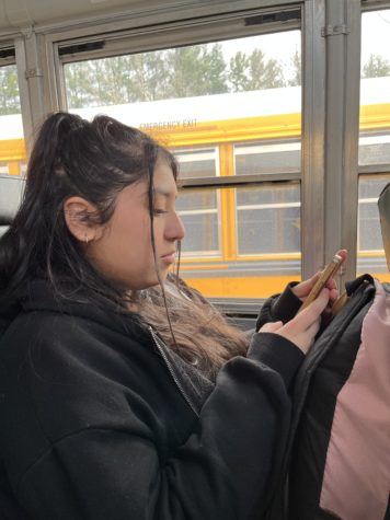 Junior Jezzel Renderos watches a true crime video on the bus on Mar. 21.