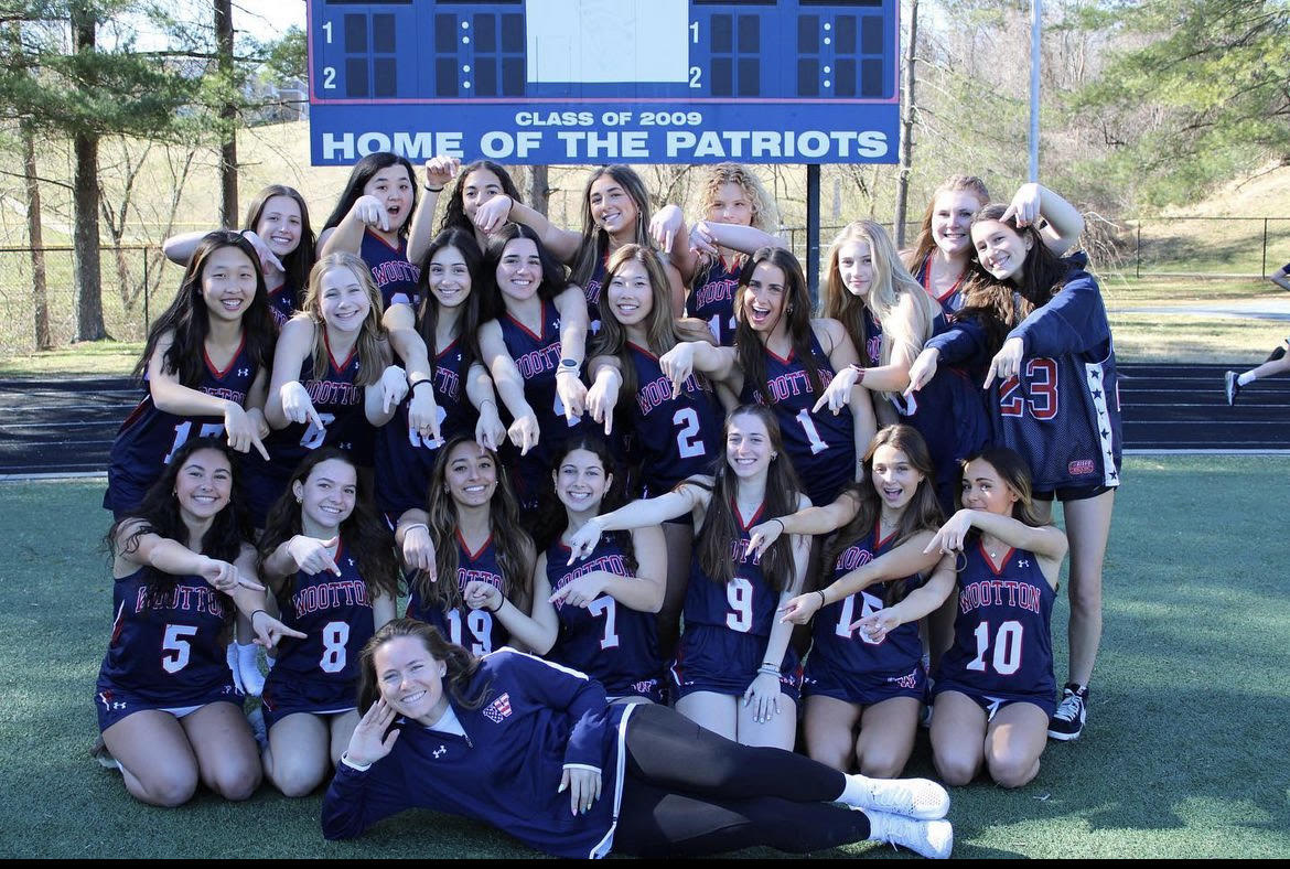 The girls varsity lacrosse team celebrates their new coach on team picture day.