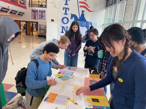 Club co-president Angela Wang (far right) helps students write letters at the Amnesty International Letter writing event.