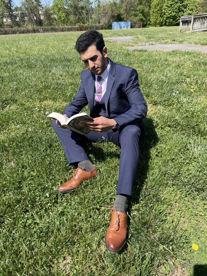 Sophomore Kian Hamidzadeh sits outside reading Rule of Wolves by Leigh Bardugo on Apr. 25.
