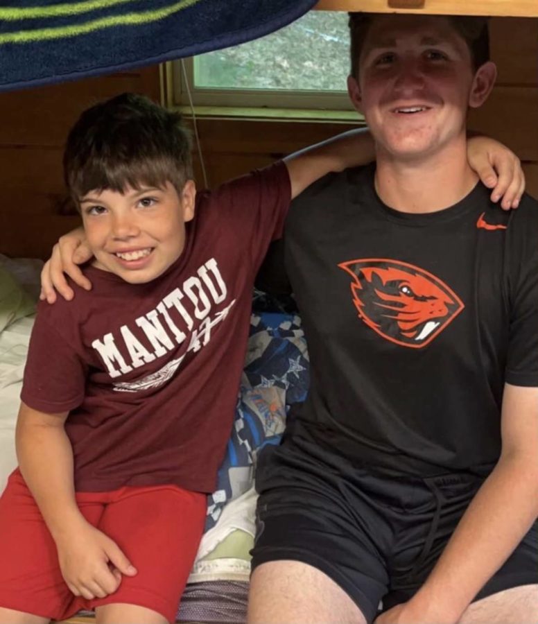 Senior Mason Berk with his favorite camper at Camp Manitou where he works as a camp counselor every summer.