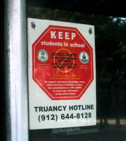 A Keep students in schools truancy hotline road sign encourages students to attend school.