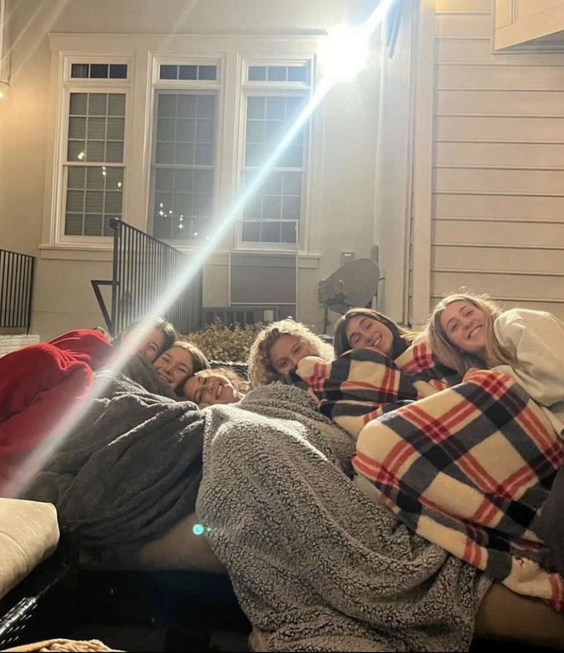 Seniors Josie Starr, Dani London, Mandy Schoen, Gillian Berman, Julia Lvovsky, and Brooke Pitt snuggle during a summer camp fire.