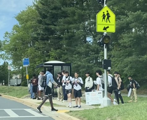 Students wait at the bus stop after school for the MCDOT Ride On bus to arrive.