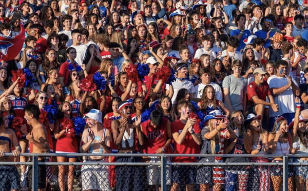Dressed in red, white and blue, students gather in the stands to cheer for the football team.