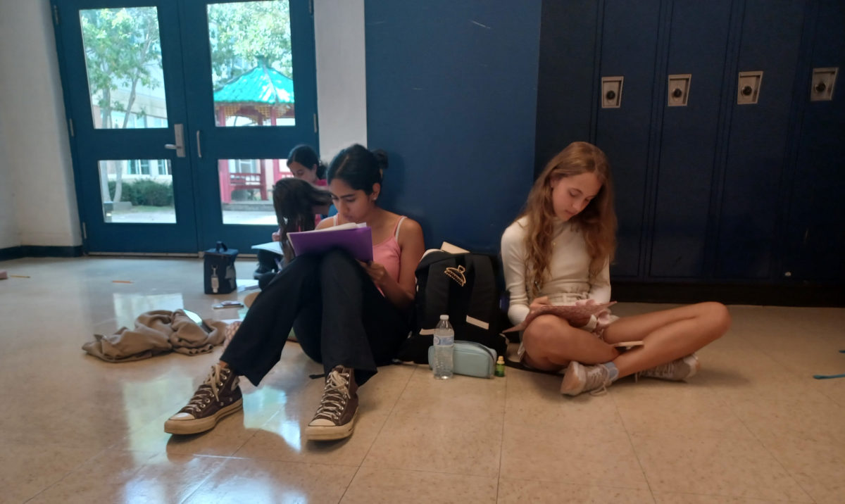 Freshmen+Laya+Hudaravalli+and+Hania+Zawadka+review+their+audition+packets+outside+of+Room+130+on+Sept.13+.