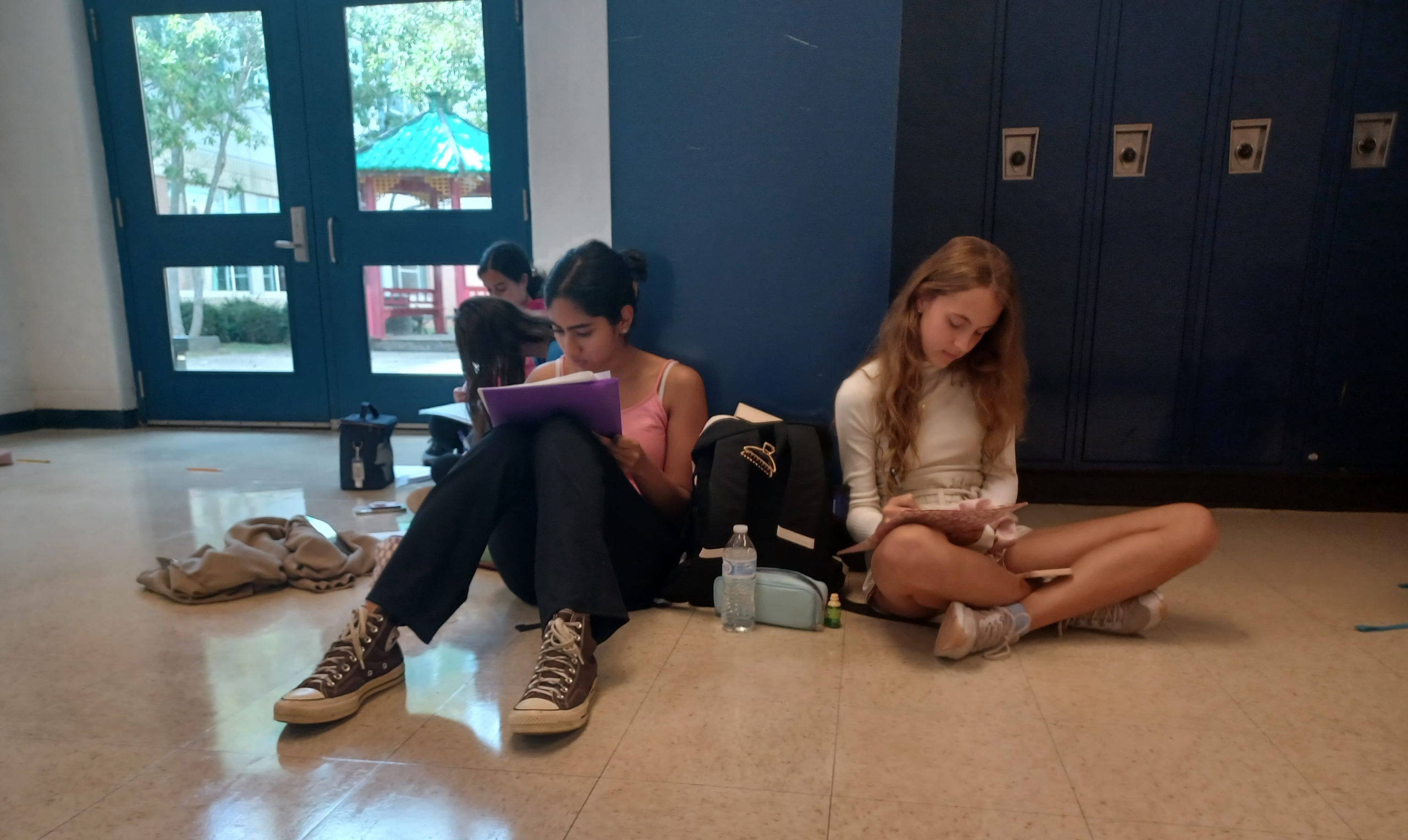 Freshmen Laya Hudaravalli and Hania Zawadka review their audition packets outside of Room 130 on Sept.13 .
