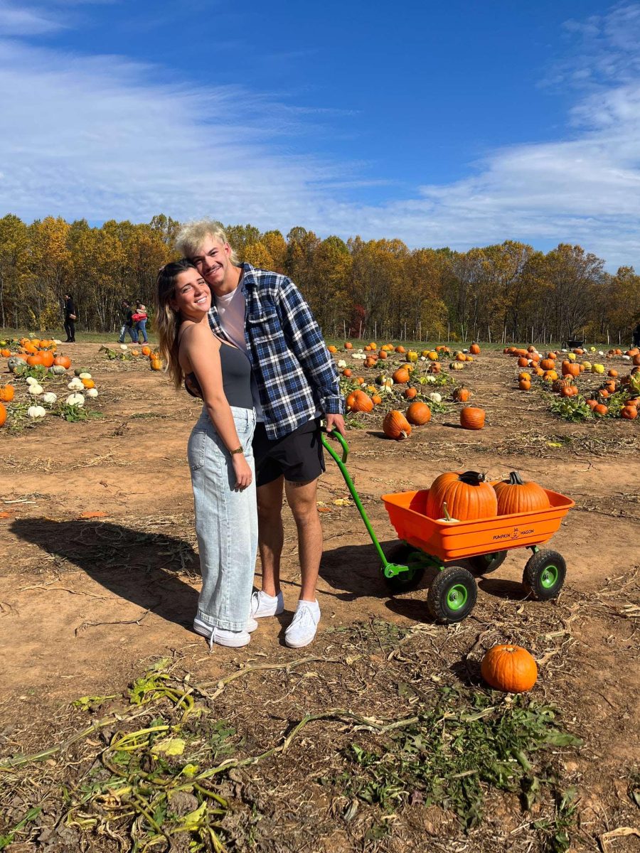 Senior Sivan Gil and 2023 alum Josh Erd pick pumpkins at Homestead Farm.