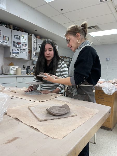 Art teacher Malinda Pierce helps freshman Grayson Burns with clay during her second period ceramics class on Nov.  20.
