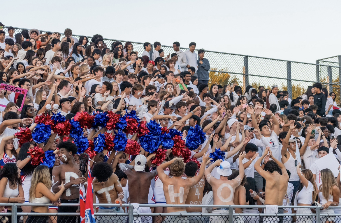 The student section erupts in cheers at the football game against Churchill on Sept. 14. Im upset I had to leave early to do homework since the game was on a Thursday, senior Lizzie Misovec said.